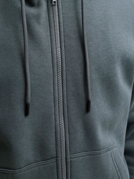 Close-up van de rits en het trekkoord van een donkergroene hoodie.