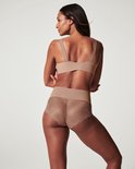 Model op de rug gezien met beige hipster met kanten afwerking en brede tailleband.