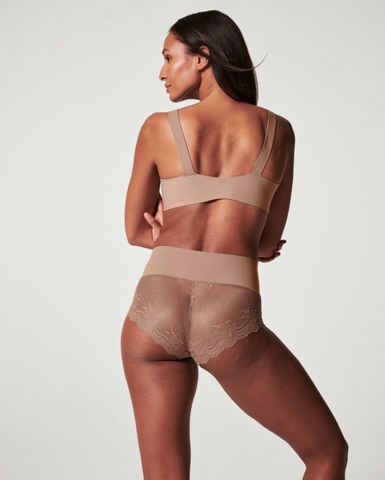 Model op de rug gezien met beige hipster met kanten afwerking en brede tailleband.