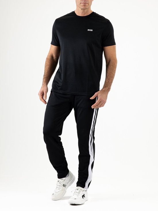 Man in een zwarte Sjeng Sports JANOS sportbroek en bijpassend zwart T-shirt met Sjeng-logo op de borst.