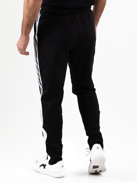 Detail van de onderkant van de zwarte Sjeng Sports JANOS sportbroek met witte zijstrepen en rits aan de enkels.