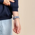 Arm van persoon met lichtblauw corduroy Apple Watch bandje.
