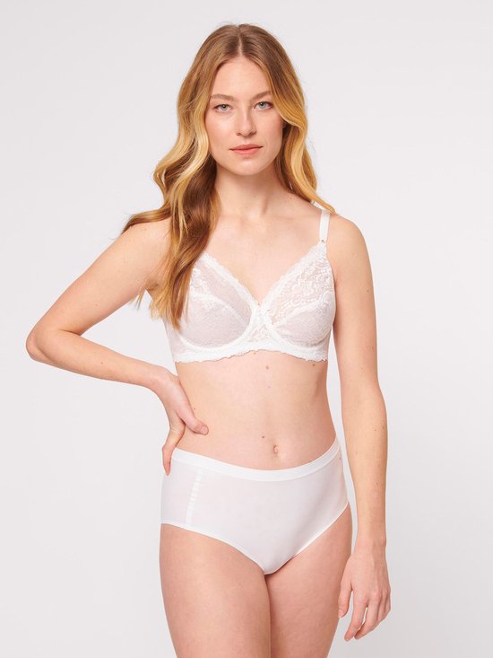 Een blonde vrouw met een witte kanten beugelbeha en witte slip.
