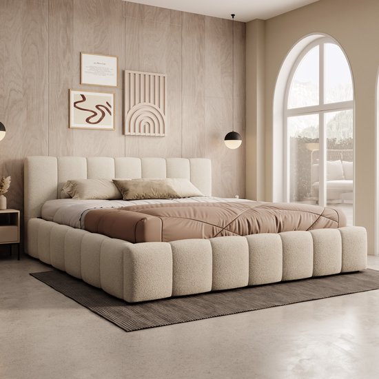 Gedetailleerd aanzicht van een beige teddystoffen bed met verticale panelen in een kamer met een groot boogvenster.