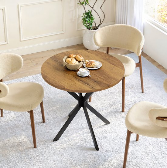 Ronde eettafel met houtkleurig blad en zwart metalen X-onderstel, omringd door drie crèmekleurige stoelen.