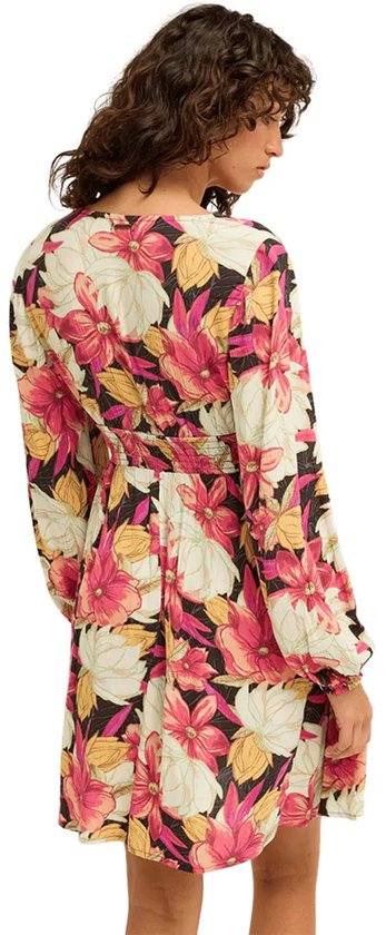 Model met de rug naar de camera, draagt een veelkleurige jurk met lange mouwen en bloemenprint, ceintuur in de taille.