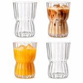 Vier geribbelde glazen, twee leeg en twee gevuld met ijscoffee en sinaasappelsap.