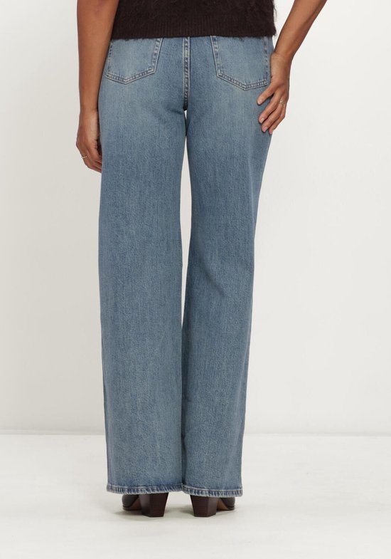 Achterkant van een lichtblauwe spijkerbroek met wijde pijpen, gedragen door een model.