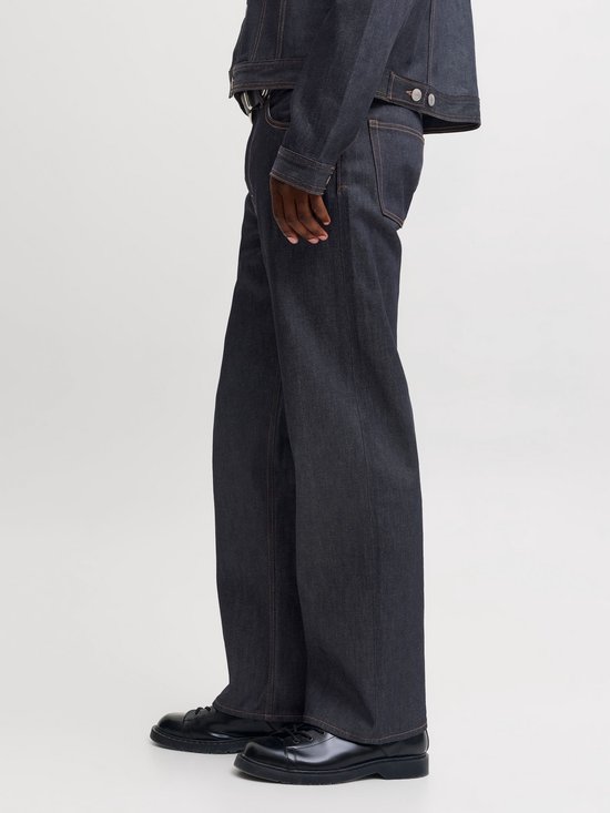 Zijaanzicht van een donkerblauwe straight fit jeans met contrasterende oranje stiksels.