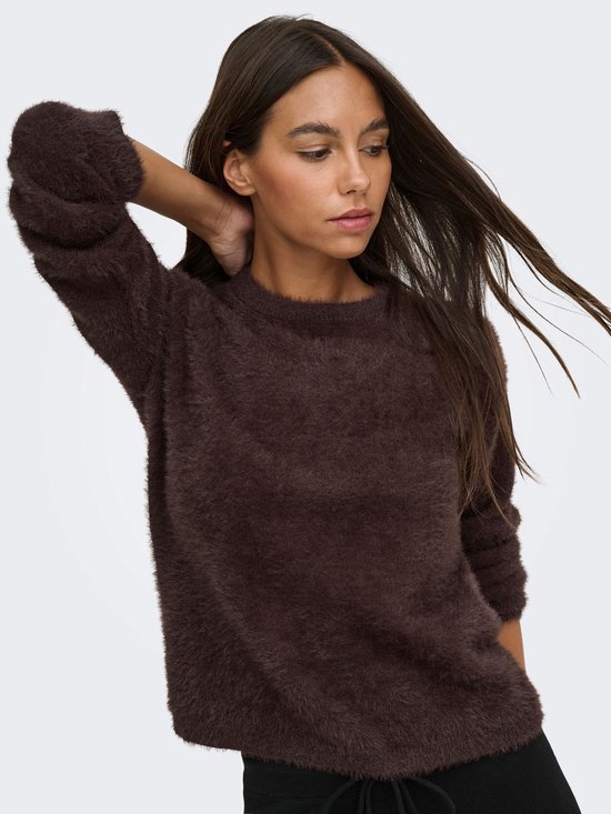 Model met hand in het haar, draagt een donkerbruine, harige trui met ronde hals.