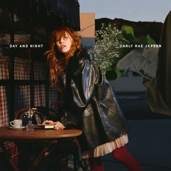 Carly Rae Jepsen in een leren jas en rood panty, leunend op een tafel met bloemen en een boek. Tekst 'DAY AND NIGHT CARLY RAE JEPSEN'.