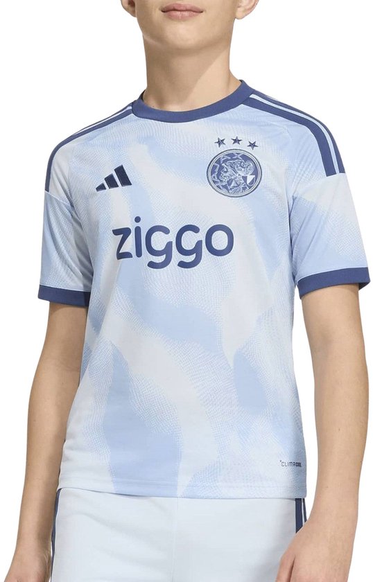 Jongen in lichtblauw Ajax shirt met donkerblauwe accenten en Ziggo-opdruk.