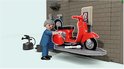 Playmobil werkplaats met rode Vespa scooter op een lift en monteur in blauw uniform.
