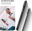 Een man met een t-shirt bekijkt zijn smartphone met Spigen Liquid Air hoesje.