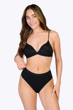 Model draagt een zwarte kanten triangel bh met dunne bandjes en zwarte high-waisted slip.