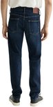 Man met donkerblauwe jeans aan, met gele sierstiksels en bruin label.