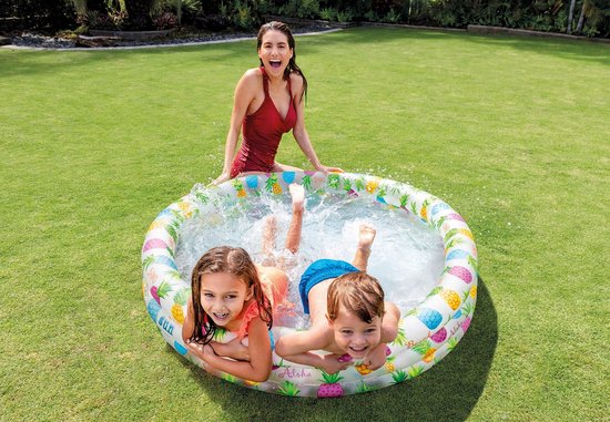 Een moeder en twee kinderen genieten van een dagje uit in de zon in een opblaasbaar zwembad.