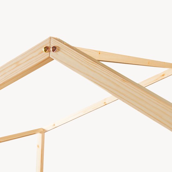 Connexion d'angle détaillée du lit maison en bois avec des vis.