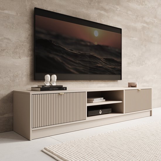 Beige tv-meubel met ribbeldeuren en open vakken. Het meubel is 180 cm breed en voorzien van gouden handgrepen.