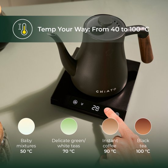 Zwarte waterkoker met houten handvat op een basis met display. Hand kiest 90°C voor instant koffie.