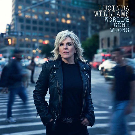 Lucinda Williams op straat met zwarte leren jas, tekst: Lucinda Williams World's Gone Wrong.