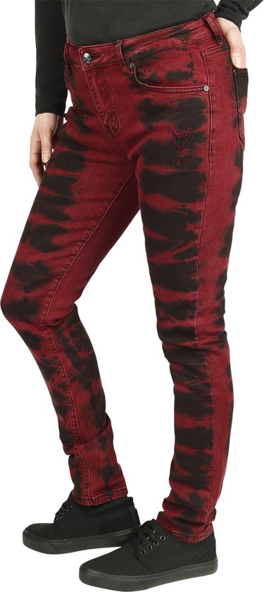 Zijaanzicht van een vrouw die een rode skinny jeans met zwarte batikprint draagt.