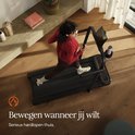 Vogelperspectief van een vrouw die op een zwarte loopband traint in een modern huis.