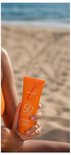 Vrouw met zonnebrandcrème met SPF 50 op het strand.