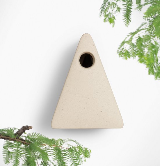 Lichtbeige driehoekig vogelhuisje met ronde ingang tegen een witte achtergrond.