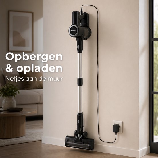 Zwarte steelstofzuiger met zilveren steel hangt aan een muurbevestiging, aangesloten op een lader. "Opbergen & opladen Netjes aan de muur".