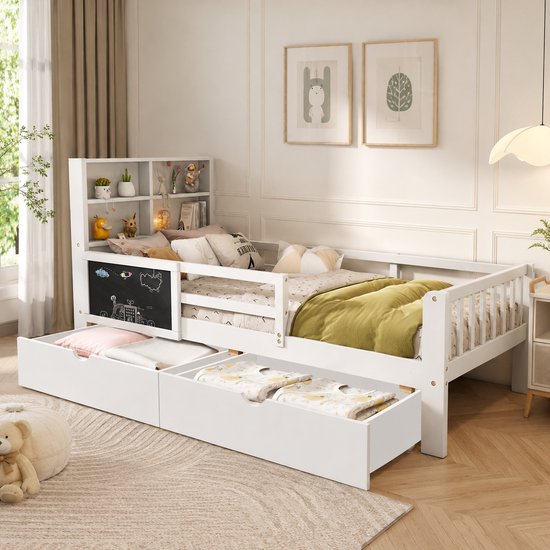 Wit kinderbed met twee lades, boekenplank en krijtbord. Opgetuigd met beddengoed en decoratie.