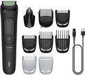 Zwarte Philips All-in-One trimmer met diverse opzetstukken voor neus, gezicht, haar en lichaam, en een USB-oplaadkabel.