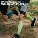 Twee renners in bosrijke omgeving, één met blauwe en de ander met lichtgroene compressiekousen.