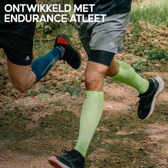 Twee renners in bosrijke omgeving, één met blauwe en de ander met lichtgroene compressiekousen.