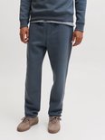 Close-up van een man in donkerblauwe joggingbroek, sneakers.