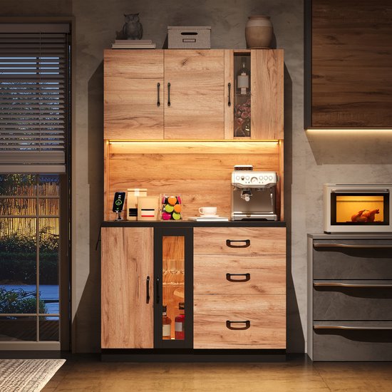 Hoge keukenkast met houtlook fronten, zwart werkblad en sfeervolle ledverlichting.