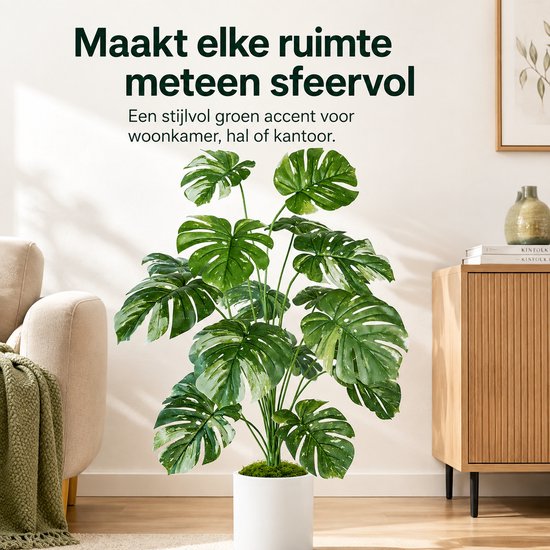 Plante artificielle verte Monstera aux feuilles tachetées multicolores dans un pot blanc, dans un salon décoré de manière attrayante.