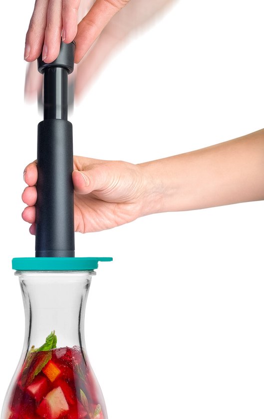 Handen gebruiken een zwarte vacuümpomp op de turquoise deksel van een glazen karaf.