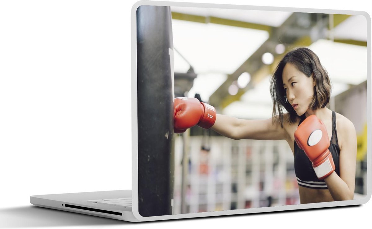 Afbeelding van product SleevesAndCases  Laptop sticker - 14 inch - Een boksende vrouw deelt een klap uit aan de boksbal