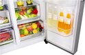 Koelkastdeur open met schappen gevuld met diverse dranken en fruit, waaronder sinaasappels en citroenen.