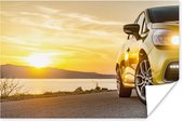 Une voiture brille à un coucher de soleil le long de la plage Poster 180x120 cm - Tirage photo sur Poster (décoration murale salon / chambre) / Poster Mer et lacs XXL / Groot format! / Mer et plage