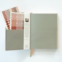 Opengeklapte planner met stickers voor maanden, notitiepagina en informatie in het Nederlands.