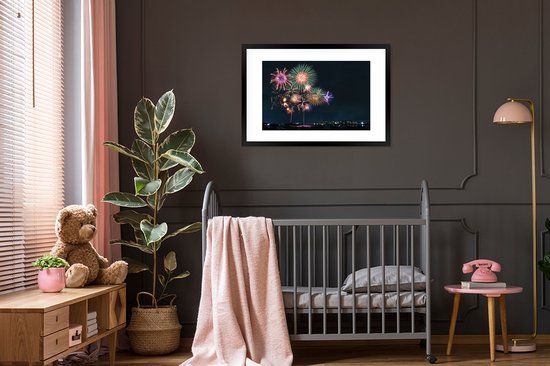 Photo en cadre - Une image de feu d'artifice dans une ville pendant le nieuw An Cadre photo noir avec passe-partout blanc grand 90x60 cm - Affiche sous cadre (Décoration murale salon / chambre)