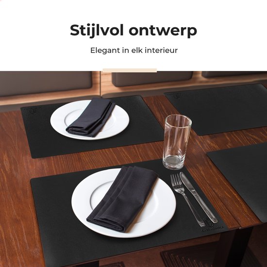 Sets de table noirs sur table en bois, dressés pour quatre personnes avec assiettes et couverts.