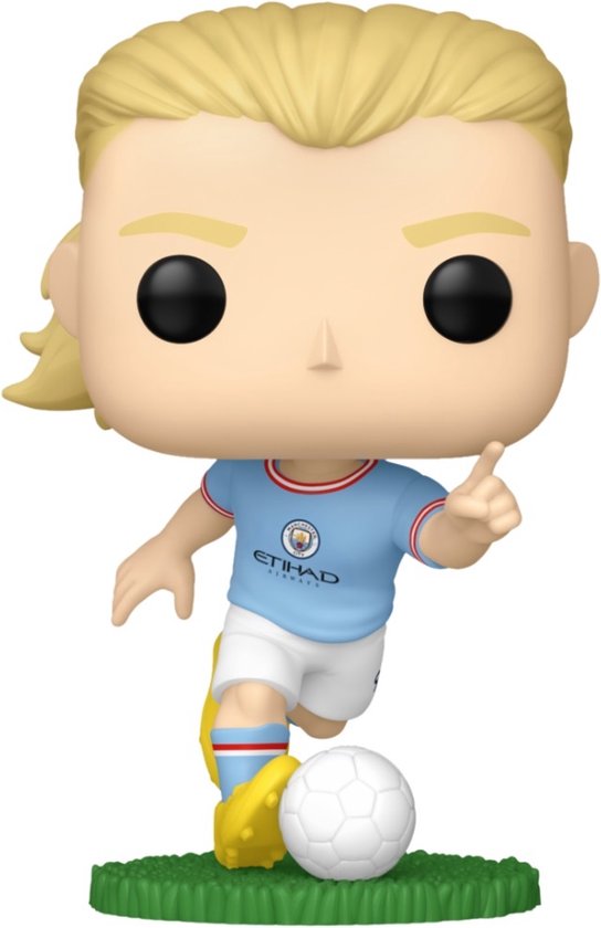 Figurine Funko Pop! Erling Haaland en tenue bleu clair Manchester City avec ballon au pied, sur herbe verte.