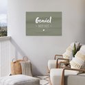 Donkergroene banner met witte tekst 'Geniet - Meer Niet -' en een hartje, hangend aan een witte muur op een balkon met lounge stoelen.
