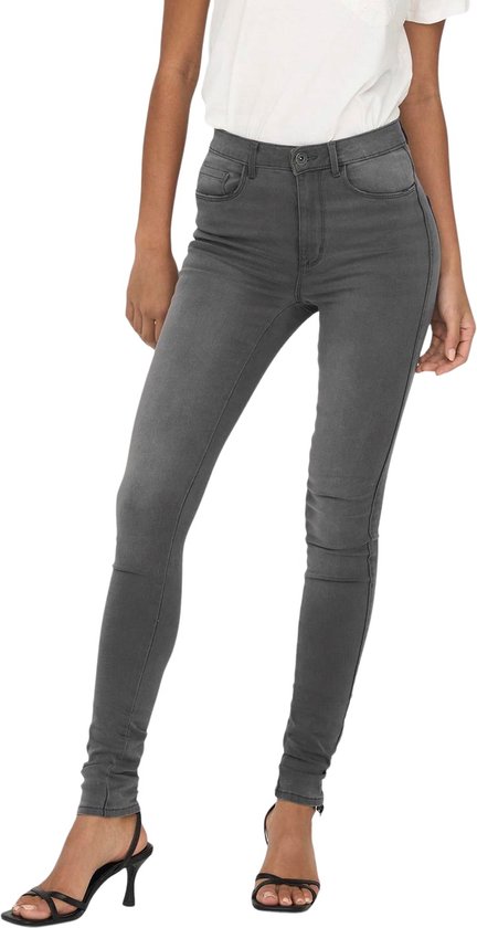 Model draagt een grijze skinny jeans met witte korte mouwen top.
