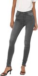 Model draagt een grijze skinny jeans met witte korte mouwen top.
