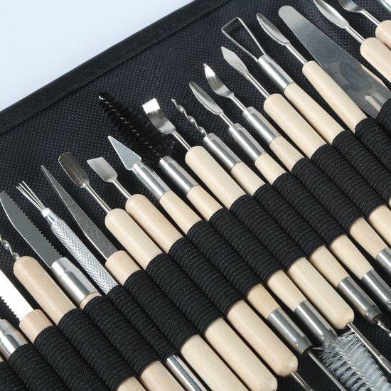 Detailopname van een uitgebreide set kleigereedschappen met houten handvatten.