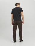 Man met de rug naar de camera, met zwart T-shirt met witte JACK & JONES-opdruk en bruine broek.